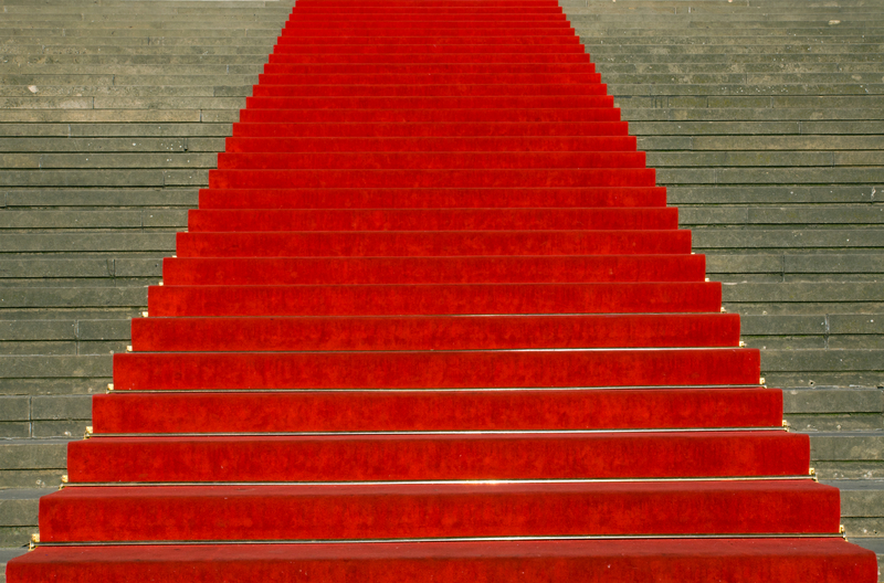concrete stairs with red carpet in the middle